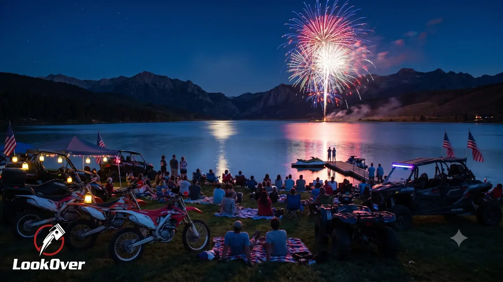 Riders and families watching Fourth of July fireworks over a mountain lake with dirt bikes, ATVs, UTVs, and jet skis parked nearby